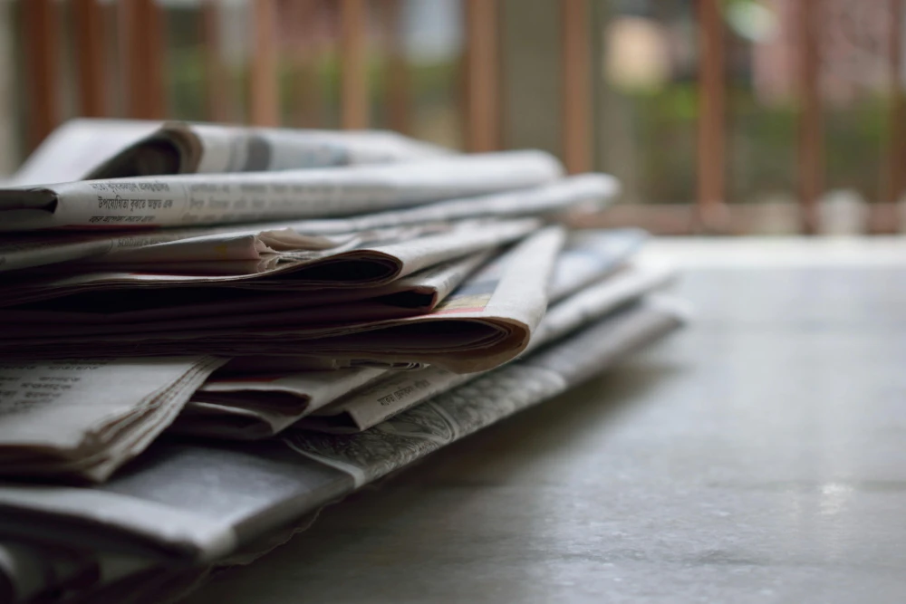 a bunch of newspapers stacked